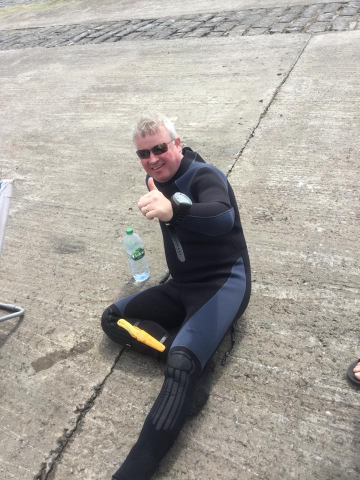 Club member in diving gear giving a thumbs up