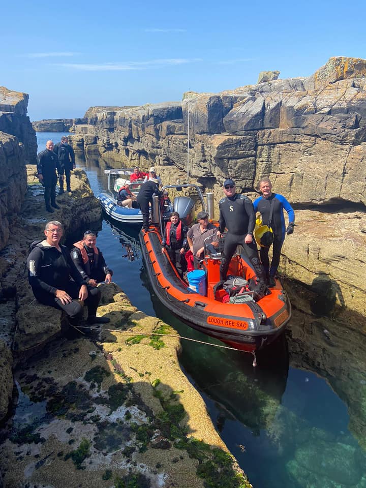 Club members with dive boats between rock formations