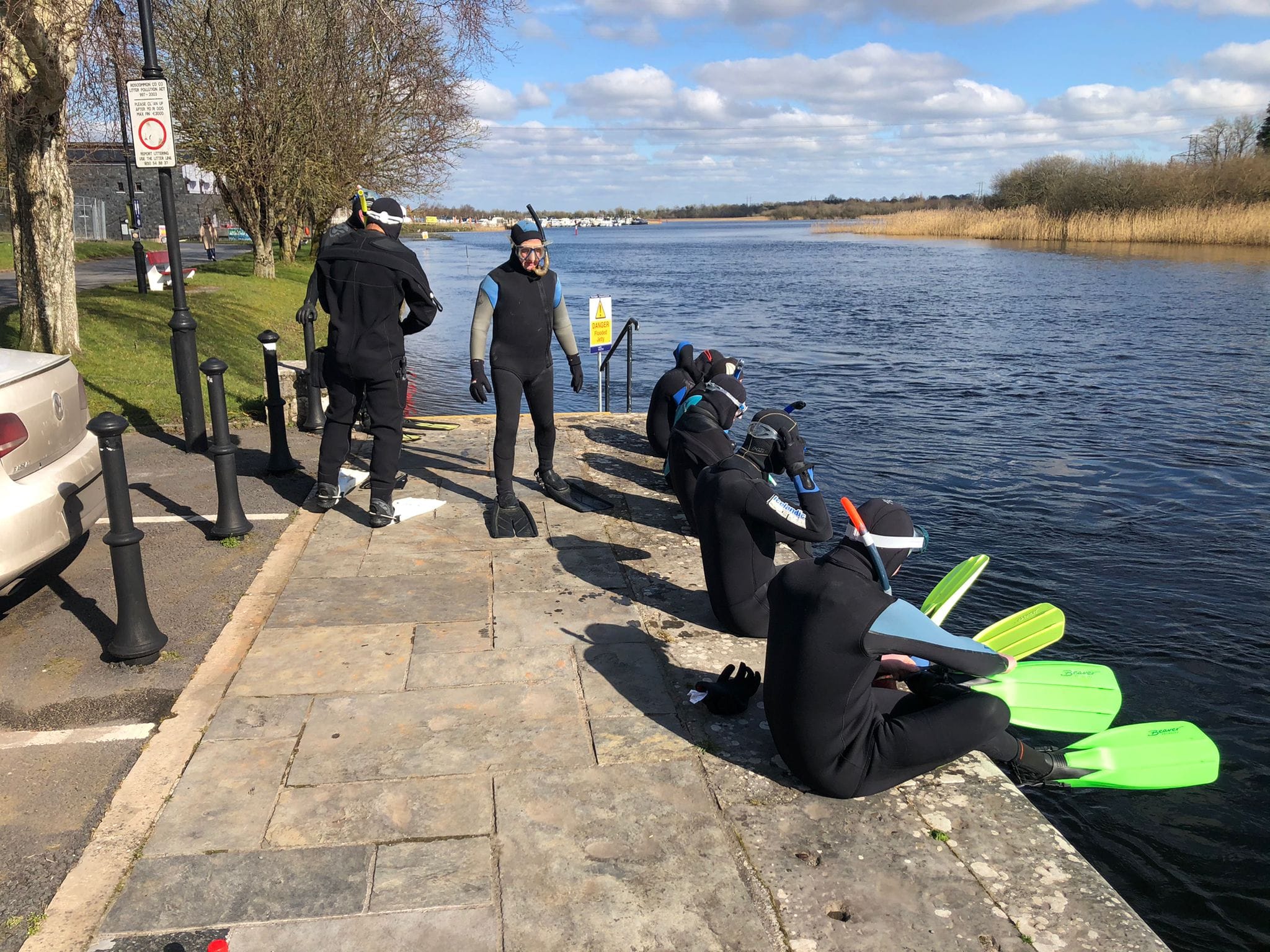 Divers preparing to enter the water from the riverside